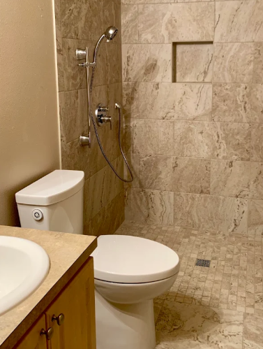 Walk-in shower and toilet in a completed tiled bathroom