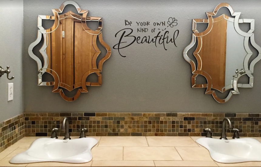 Double bathroom vanity with sculpted mirrors and matching faucets