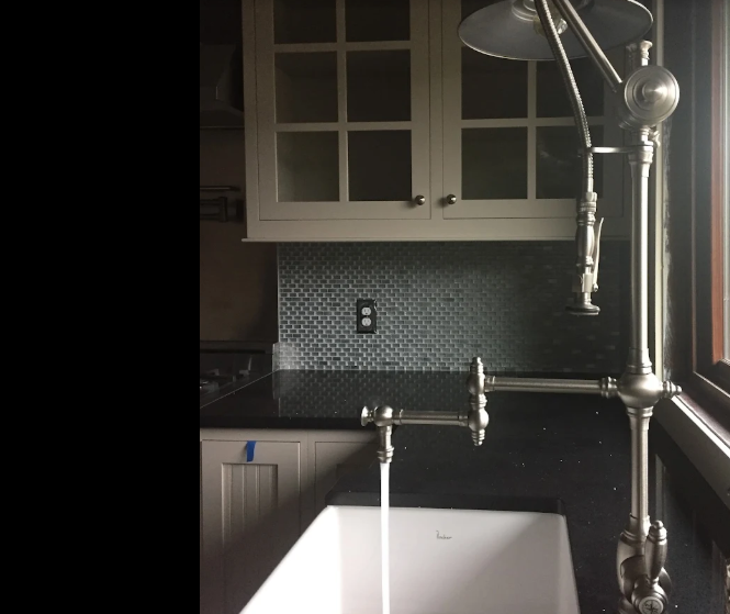 Traditional kitchen sink with an articulated metal faucet