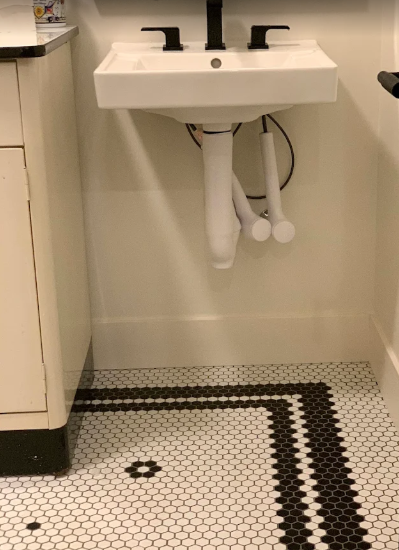 Wall-mounted sink and classic black-and-white hexagonal floor tile